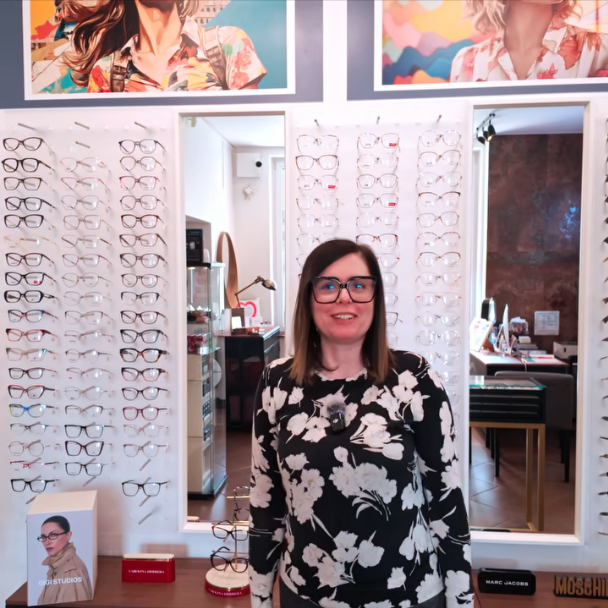 Promocja na oprawki Twoje Okulary – właścicielka salonu prezentuje ofertę -15% na oprawki na tle ekspozycji okularów w salonie.